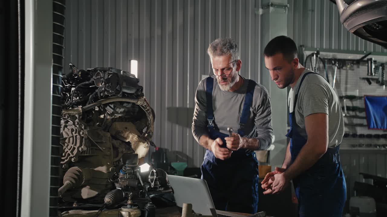 Two mechanics working on a car engine in a repair shop