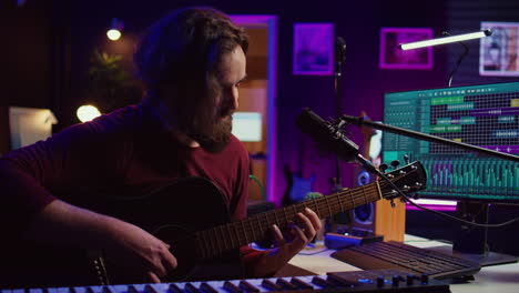 artist composing a song with his acoustic guitar in home studio