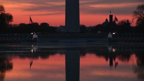 a still mirror image of the washington monument and the reflecting pool creates a stunning goldenhour scene