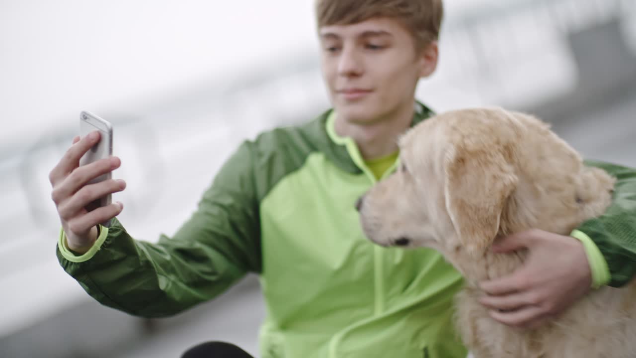 개와 셀피를 찍는 소년