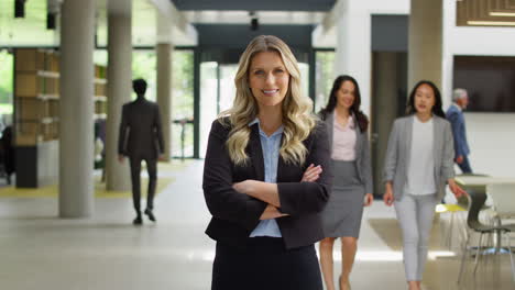 portrait of mature businesswoman ceo chairman standing in lobby of busy modern office building