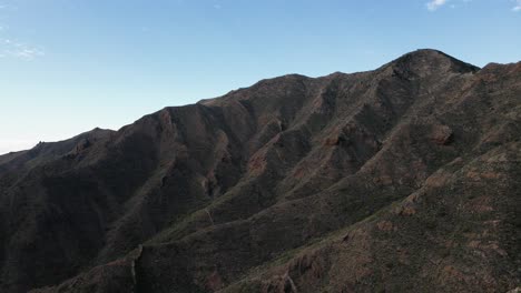 backward drone dolly revealing giant mountain range, rocky formations