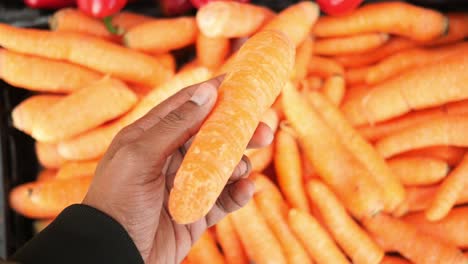 hand holding a carrot in a market