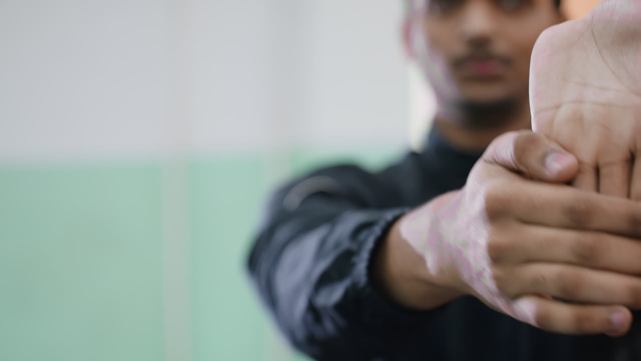 Close up of tennis player practicing wrist flexibility during indoor workout session with focus on control, muscle strength, and preparation for sports activity under soft training light