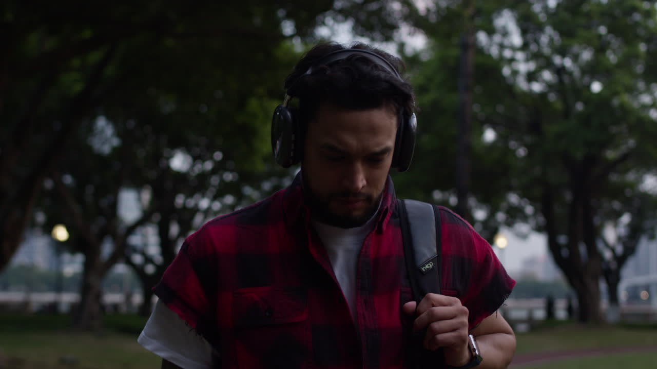 Man Walking in Park with Headphones