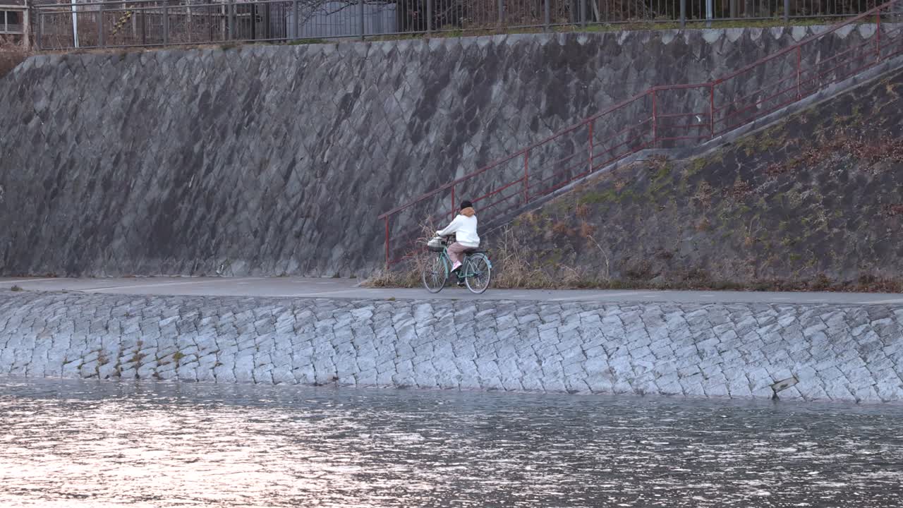 한 사람 이 가파른 강변 을 따라 자전거 를 타고 있다