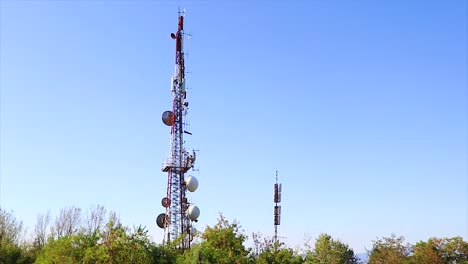 steady shot of an antenna transmitter emitting radio waves and receiver satellite dish