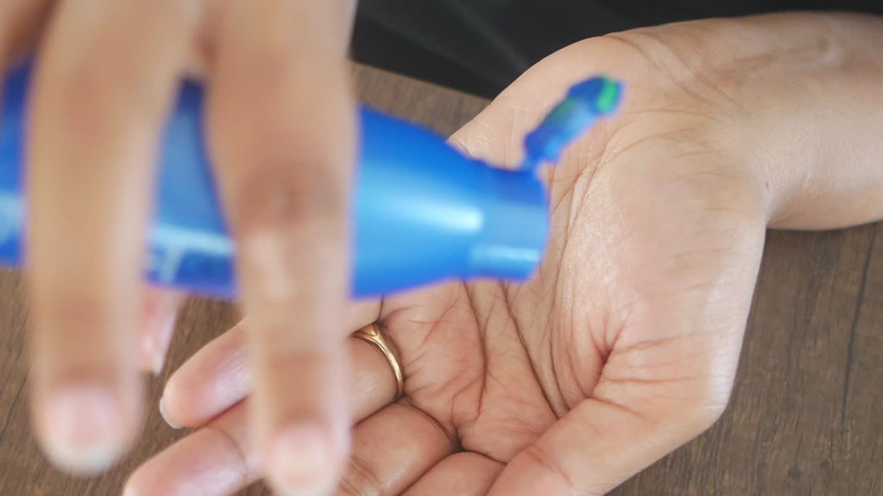 mujer aplicando loción a la mano