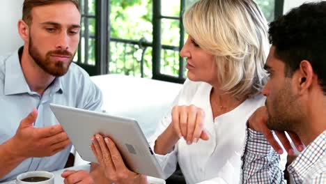 businesspeople discussing over digital tablet