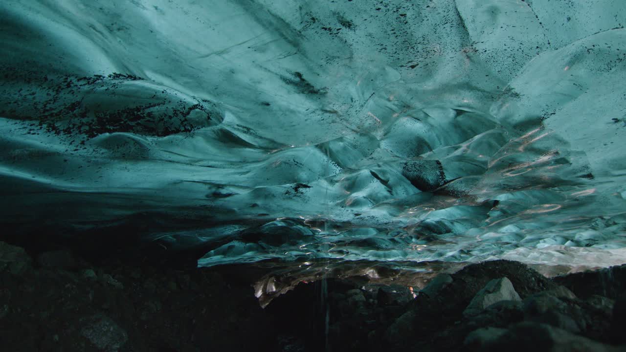 el agua fría corre a través de un pequeño agujero en el hielo en una cueva de hielo de un glaciar en islandia