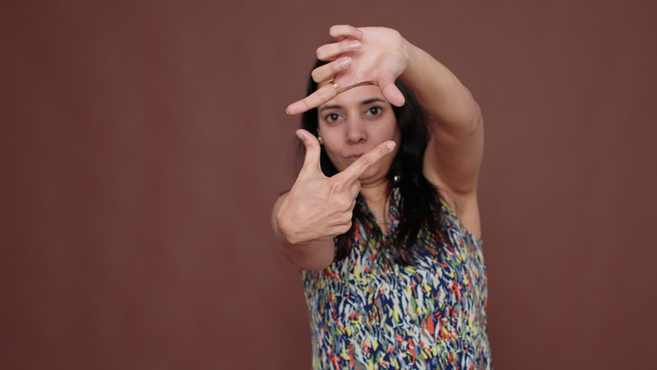 Creative indian model pretending to take picture in studio