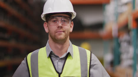 caucasian male factory worker at a factory looking and smiling to the cameractory workers at a facto