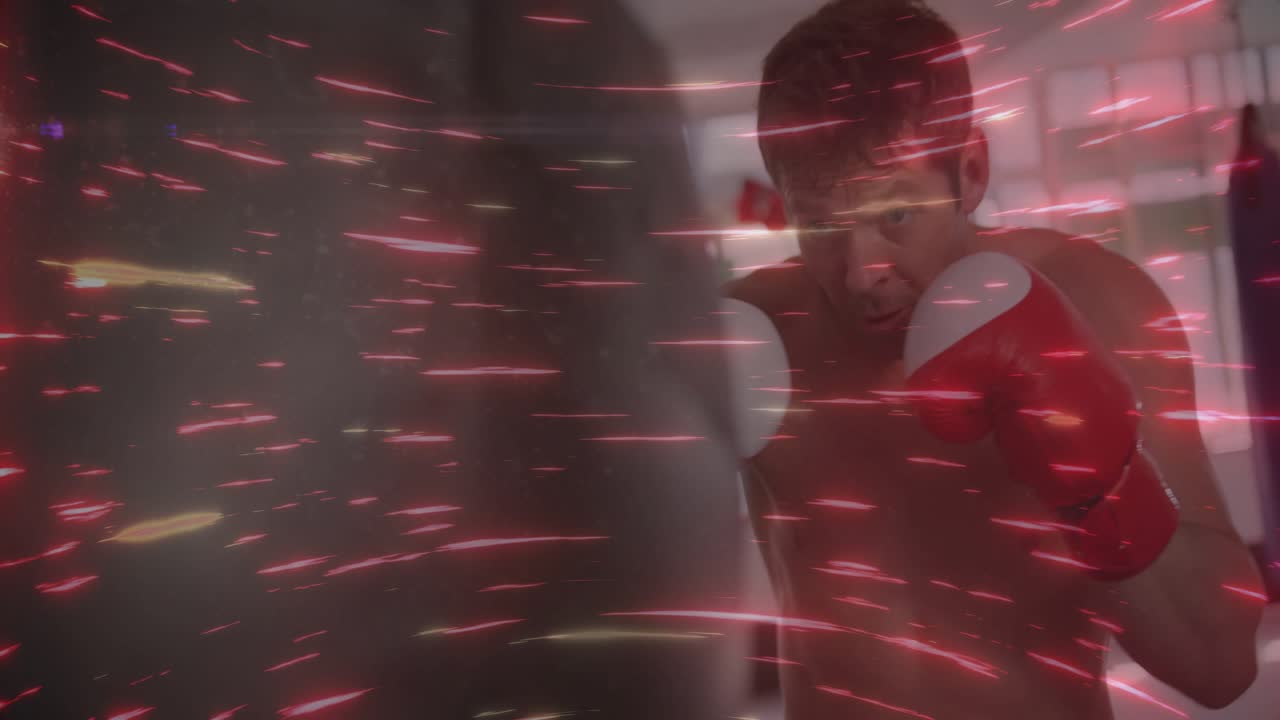 Male boxer initiating jabs and crosses by advancing on heavy bag, training with red streak overlay