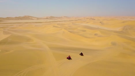 good aerials over atv vehicles speeding across the desert sand dunes in namibia africa 1