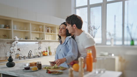 joyful spouses preparing meal for romantic breakfast in kitchen. couple cooking.