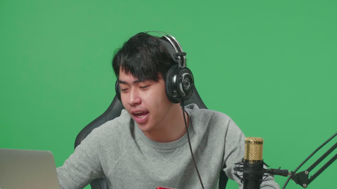 Young Man Streaming Mobile Game on Green Screen