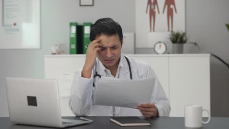 Stressed-and-tensed-Indian-doctor-checking-medical-reports