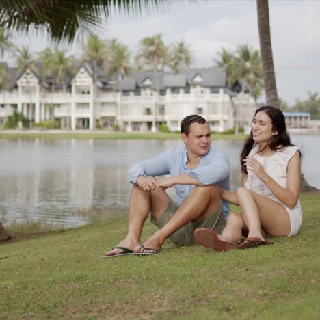 resting couple enjoying in journey while sitting on lawn at resort