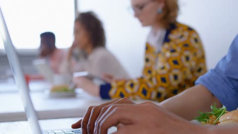 Young-multi-ethnic-business-people-using-laptop-and-digital-tablet-in-modern-office-4k