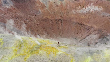 man hiking on volcano and walking trough sulfuric smokes. volcanic landscape of volcano island travel destination in sicily