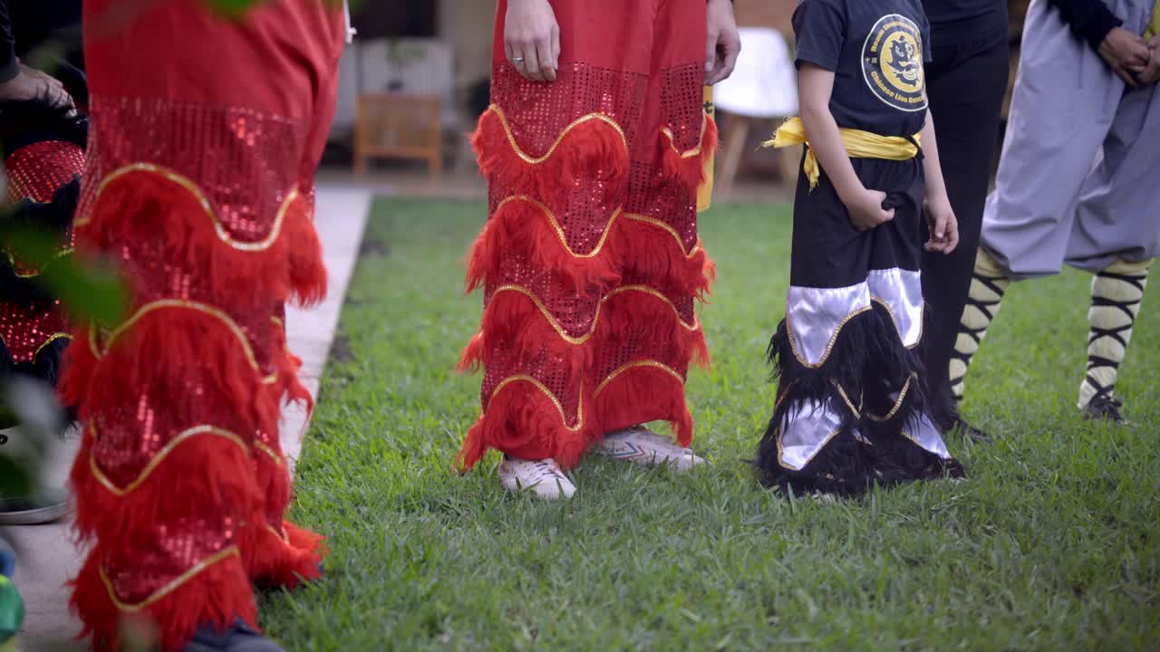 Anak-anak berkostum warna-warni bersiap untuk tarian budaya di luar ruangan