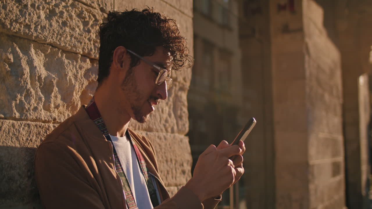 Man using phone against brick wall