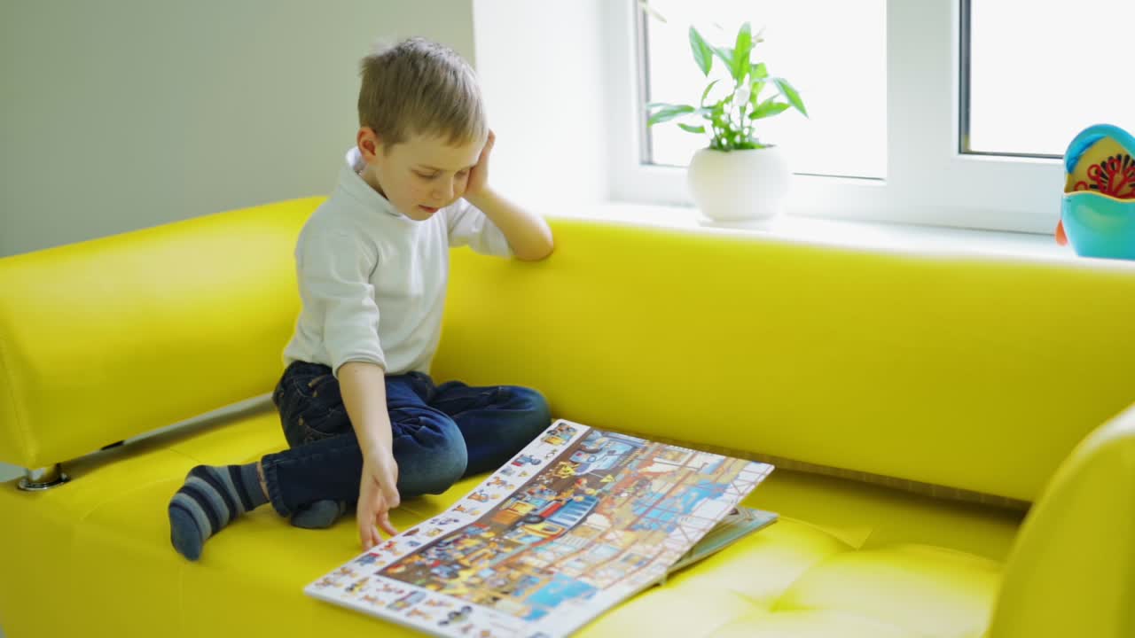 Boy with book at home. Small boy reading book in his room