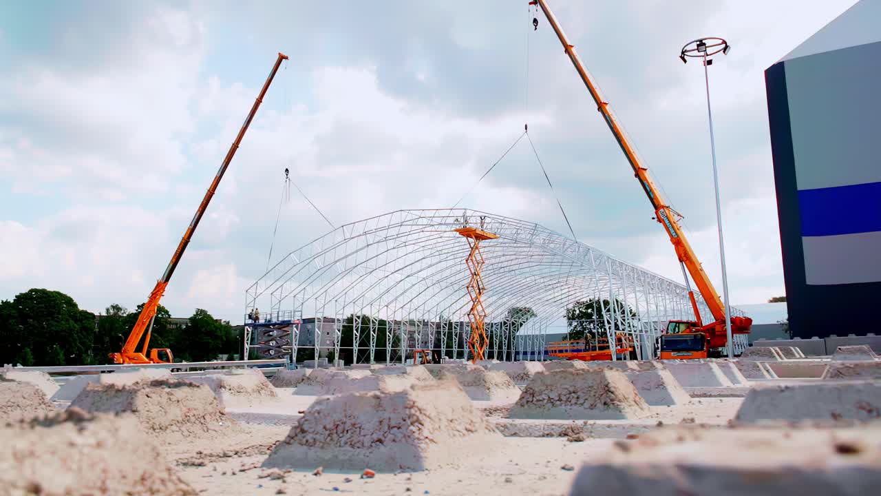 Mobile cranes building large steel framework for an industrial storage