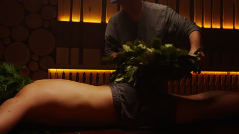 man receiving a traditional russian banya treatment