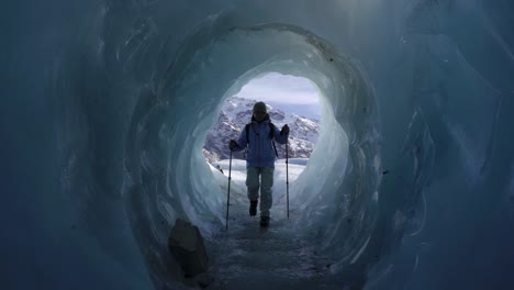 una mujer con palos de trekking dentro de la cueva de hielo del glaciar de tasmania en el parque nacional mount cook, canterbury, nueva zelanda