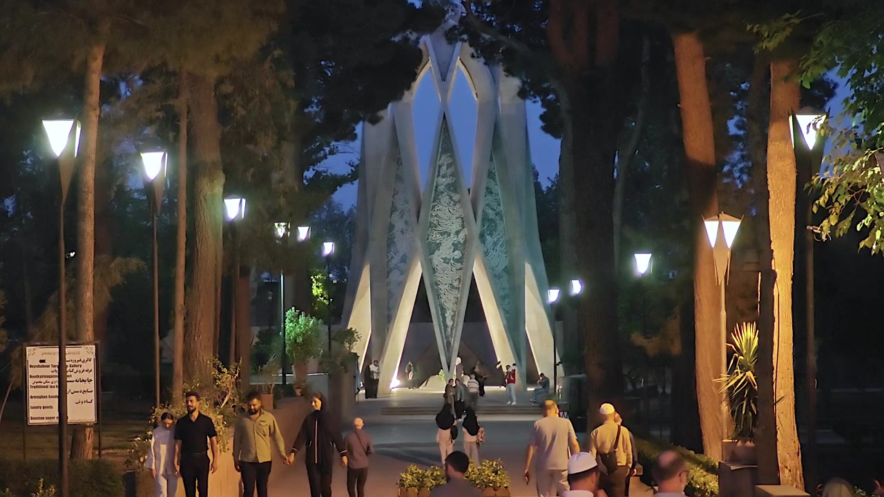 Persone che camminano nel parco di notte vicino a un monumento illuminato