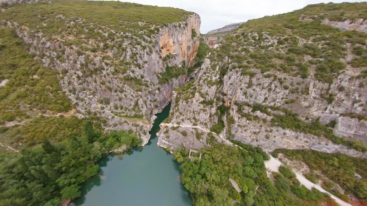 Volo FPV aereo rapido attraverso un canyon montano scenografico in Spagna