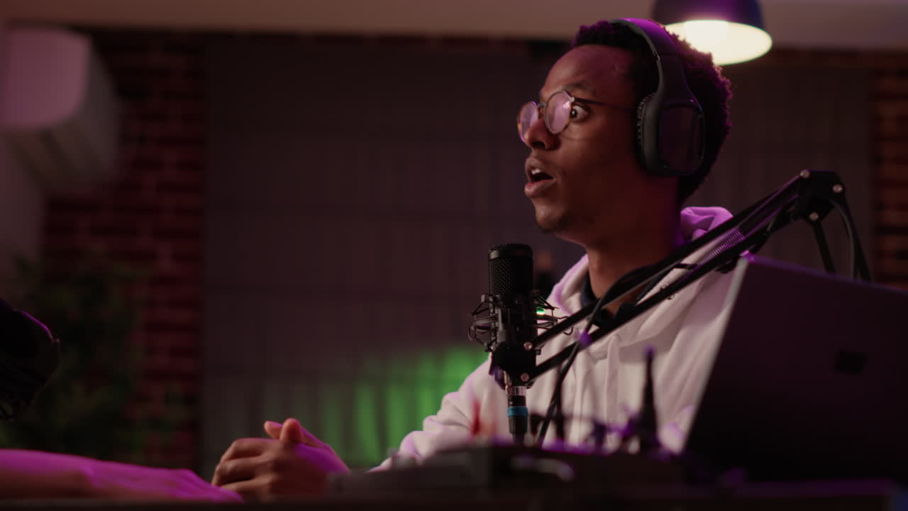 African american online radio presenter talking with influencer guest looking surprised