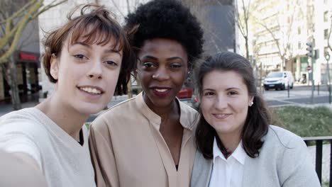 group of cheerful women talking and waving during video call