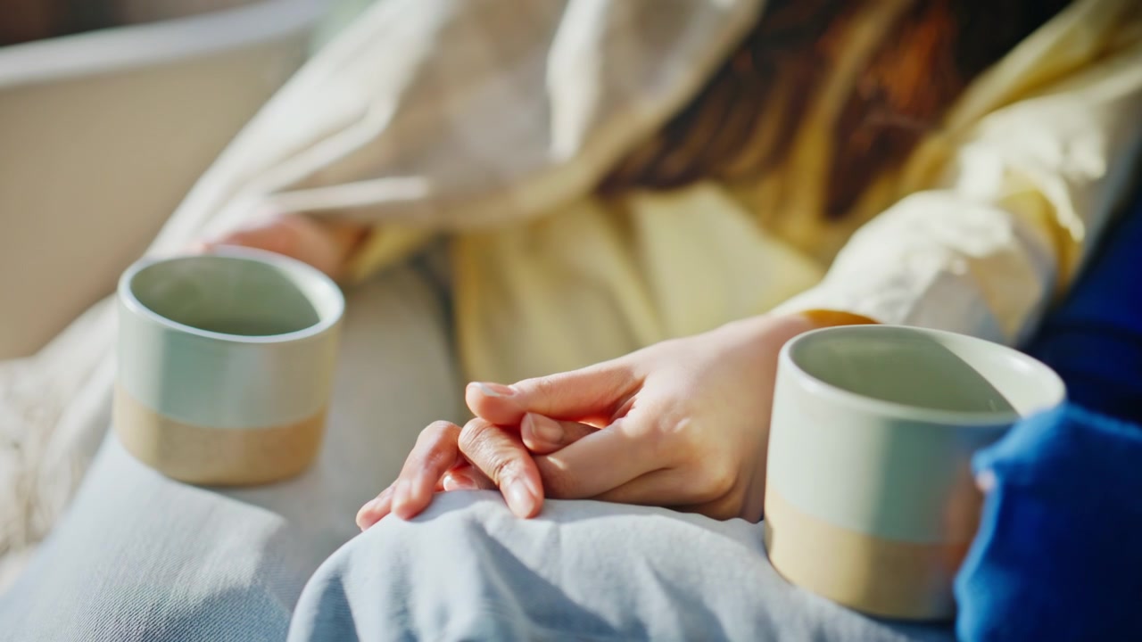 Primo piano di mani femminili che accarezzano delicatamente il divano. Donne, comfort, supporto, coperta accogliente