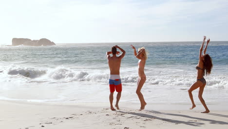 Happy-friends-jumping-at-the-beach