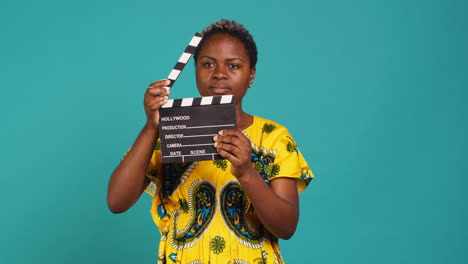 young woman movie producer clapping filming slate to cut a scene