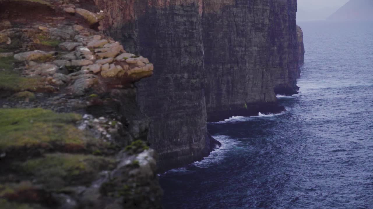 Slow motion of deep ocean,waves and bold cliffs during cloudy and stormy day