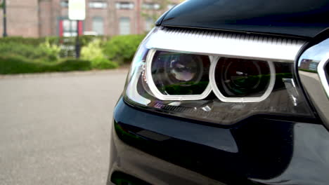 slow motion pan onto headlight of black bmw car, 120fps