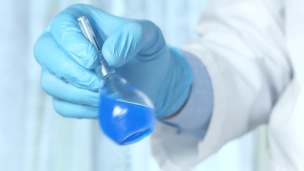 científico con un frasco de líquido azul