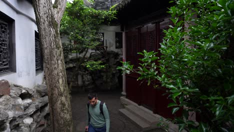 Man-with-explores-Yuyuan-Garden-for-the-first-time-in-Shanghai-admiring-traditional-Chinese-architecture