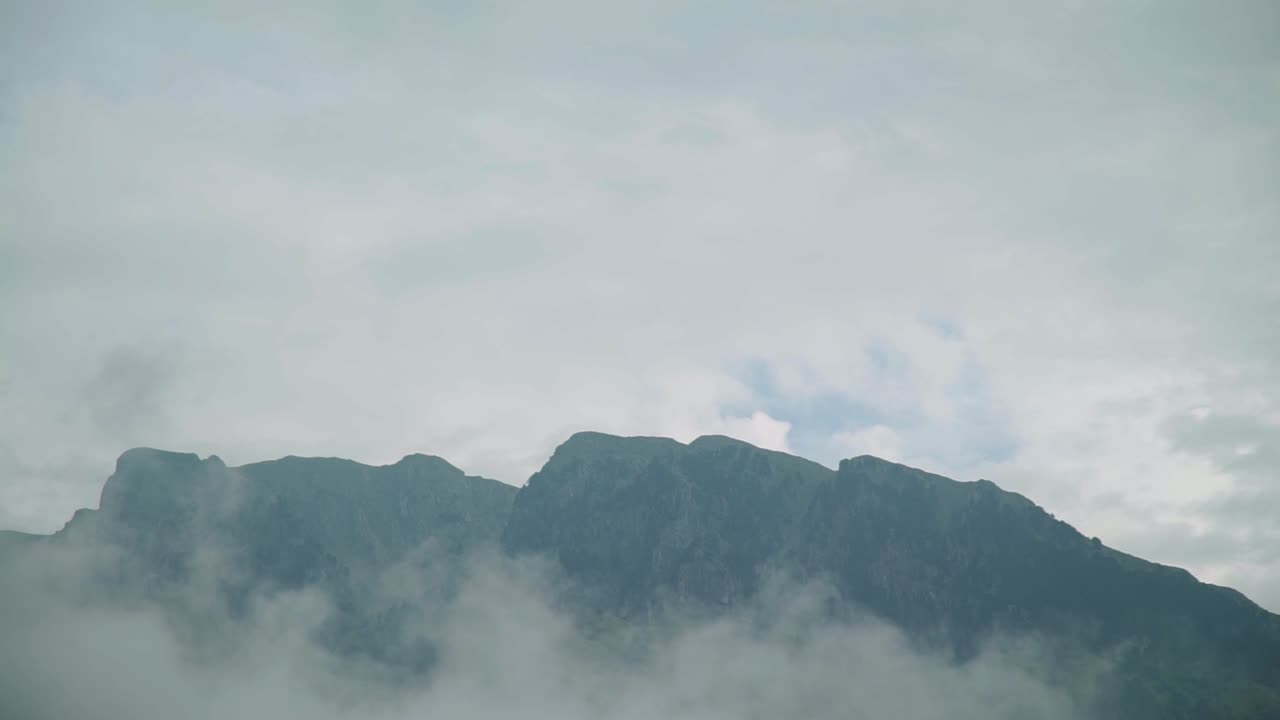 day shot of mountains top with fog , foggy mountain peak amazing rural view foggy scary feeling winter mood