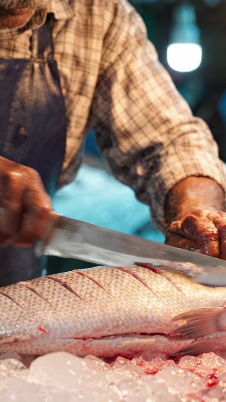 Un pêcheur expérimenté prépare habilement une pêche fraîche de poisson sur de la glace avec précision et soin dans un marché animé, mettant en valeur l'art culinaire