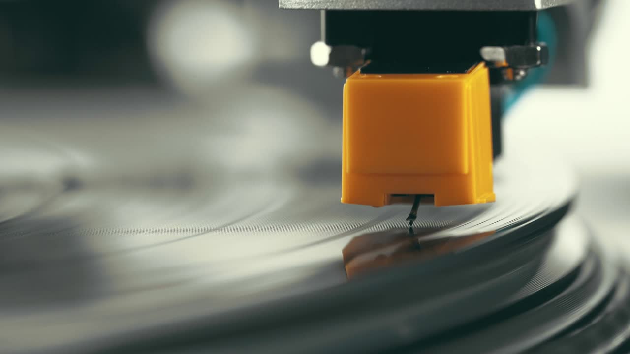 Vinyl player turntable. A fragment of a rotating vinyl record, a stylus with a needle close-up. Stopping a needle and a vinyl plate close-up. Macro
