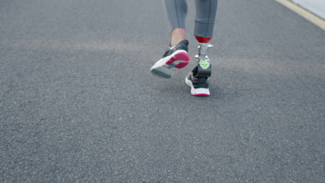 disabled woman legs running on road. sportswoman jogging on running surface