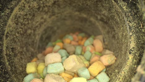 Starting-outside-lid,-pushing-towards-bottom-of-container-of-multi-colored-marshmallow-pieces