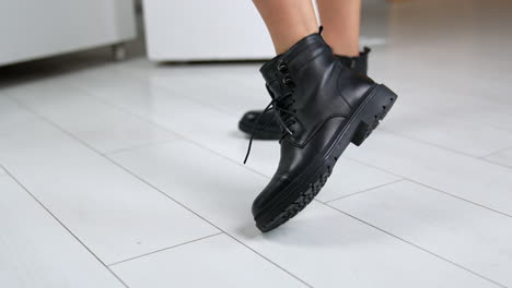 black leather ankle boots on wooden floor