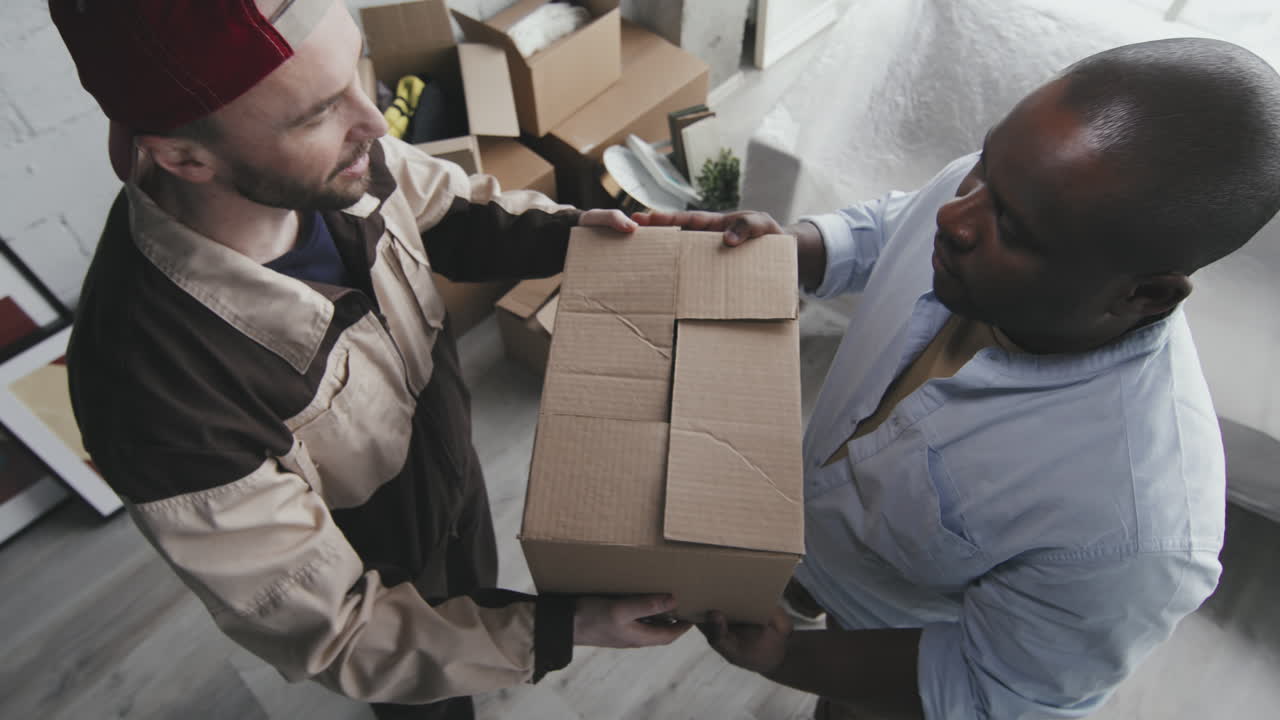 Delivery men carrying cardboard box