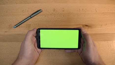 a person holding a phone with a greenscreen display