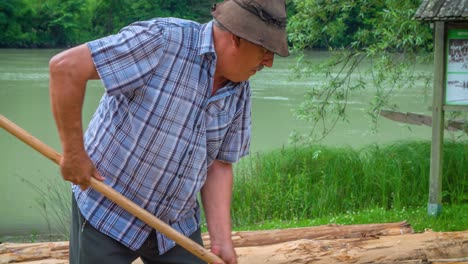 Slow-motion-of-a-skilled-raftman-wood-chiselling-at-a-timber-rafting-event